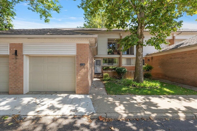 view of front facade featuring brick siding, a garage, and driveway