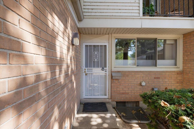 doorway to property featuring brick siding