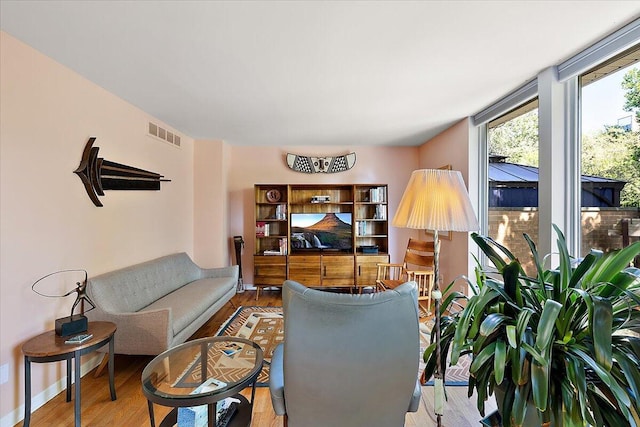 living area featuring visible vents and wood finished floors