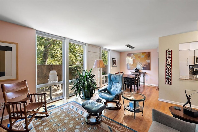living room with expansive windows, baseboards, and wood finished floors