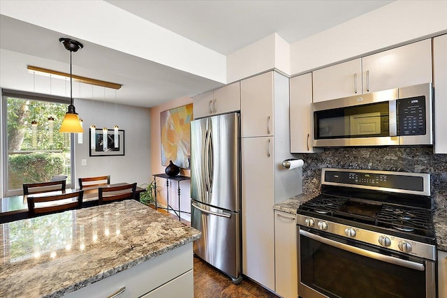 kitchen with tasteful backsplash, decorative light fixtures, dark wood finished floors, light stone countertops, and stainless steel appliances