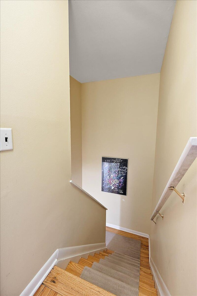 stairway featuring baseboards and wood finished floors