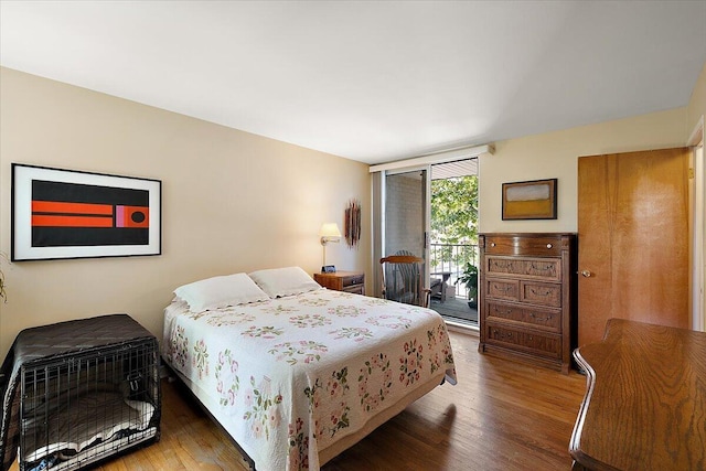 bedroom with access to outside, wood finished floors, and floor to ceiling windows