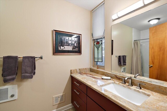 full bathroom with a shower with shower curtain, vanity, visible vents, and baseboards