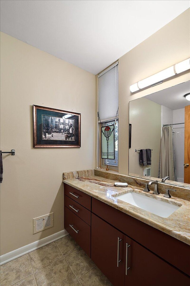 bathroom with tile patterned flooring, vanity, visible vents, and baseboards