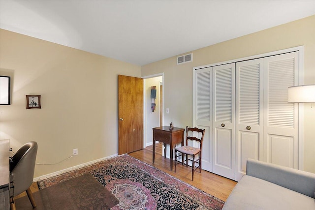 home office featuring wood finished floors, baseboards, and visible vents