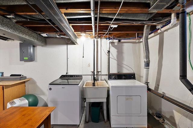 clothes washing area featuring a sink, washer and dryer, laundry area, and electric panel