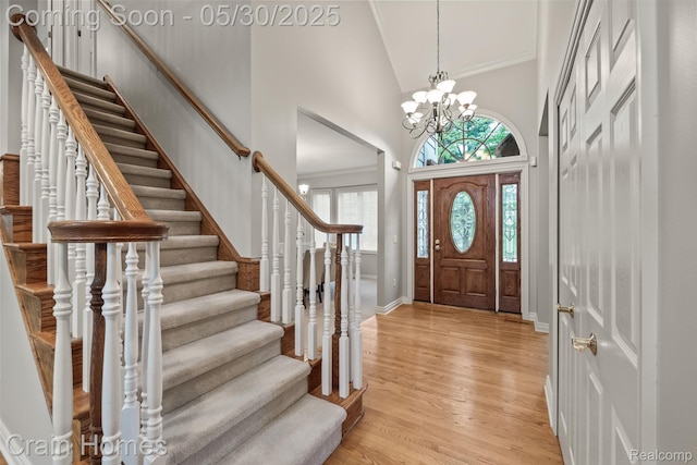 1171 Deer Path Trl, Oxford, MI 48371 - foyer entrance featuring high vaulted ceiling, light wood-type flooring, stairway, a chandelier, and plenty of natural light