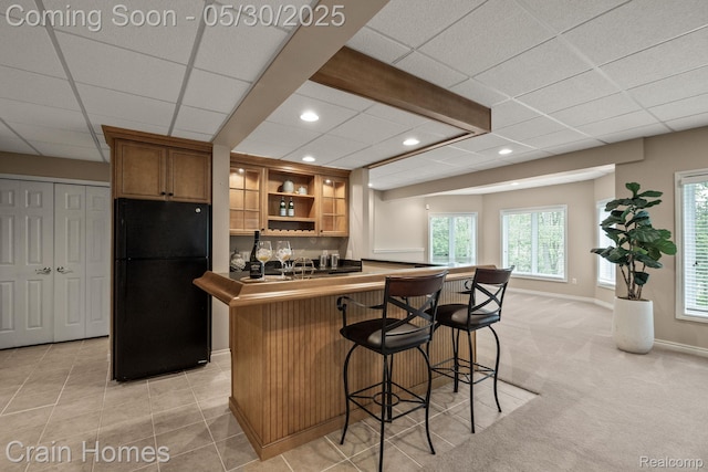 1171 Deer Path Trl, Oxford, MI 48371 - kitchen with freestanding refrigerator, open shelves, healthy amount of natural light, a kitchen bar, and a drop ceiling