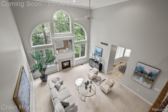 1171 Deer Path Trl, Oxford, MI 48371 - living area with a tiled fireplace, a towering ceiling, ornamental molding, ceiling fan, and baseboards