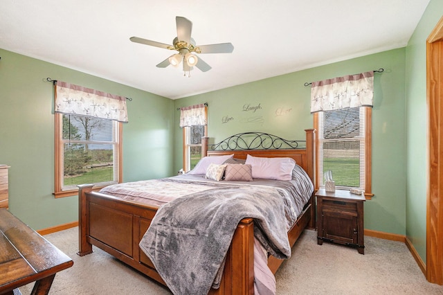 bedroom featuring light colored carpet, ceiling fan, and baseboards
