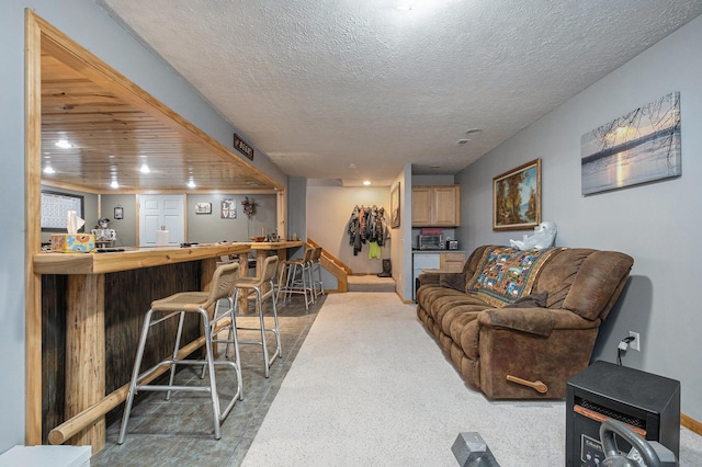 living area with baseboards, recessed lighting, a textured ceiling, and a dry bar