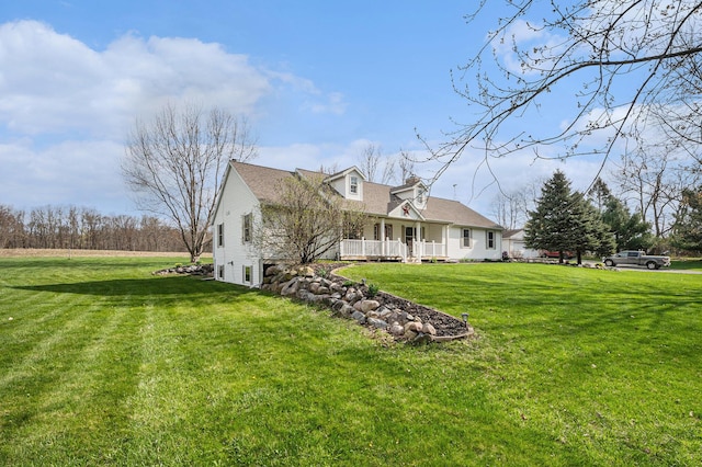 back of house featuring covered porch and a yard