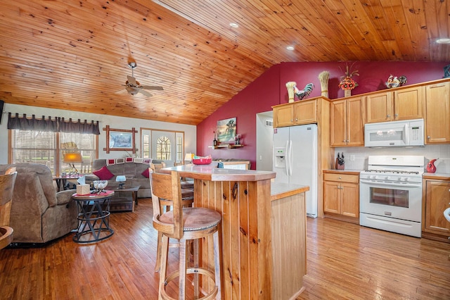 kitchen with open floor plan, light wood-style floors, white appliances, and light countertops
