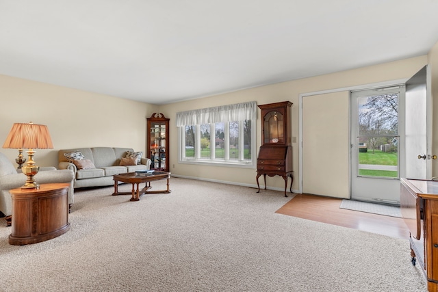 living room featuring a wealth of natural light, baseboards, and carpet floors