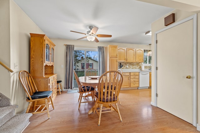 dining area featuring ceiling fan, stairway, a wealth of natural light, and light wood-type flooring
