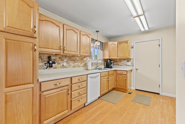 kitchen with tasteful backsplash, light brown cabinetry, light wood-style floors, white dishwasher, and a sink