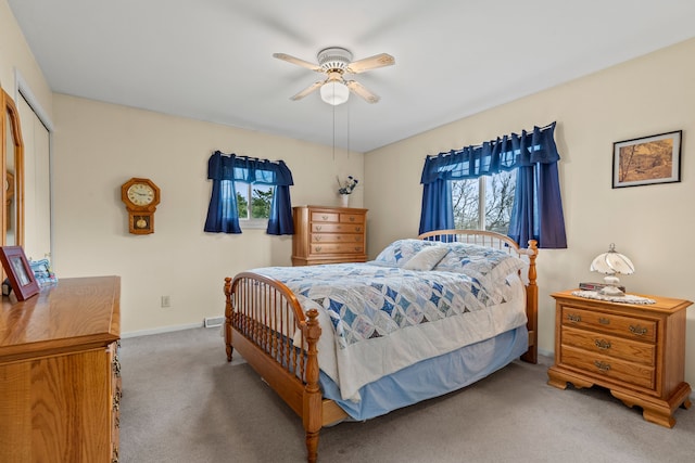 bedroom with baseboards, a ceiling fan, a closet, and carpet