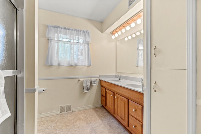 full bath with visible vents, double vanity, and a sink