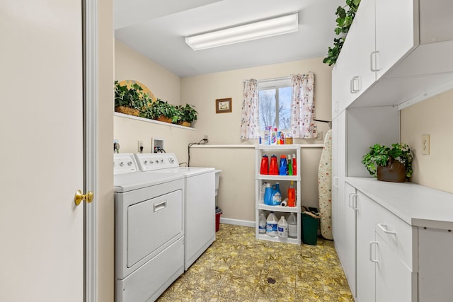 washroom with baseboards, cabinet space, and washing machine and dryer