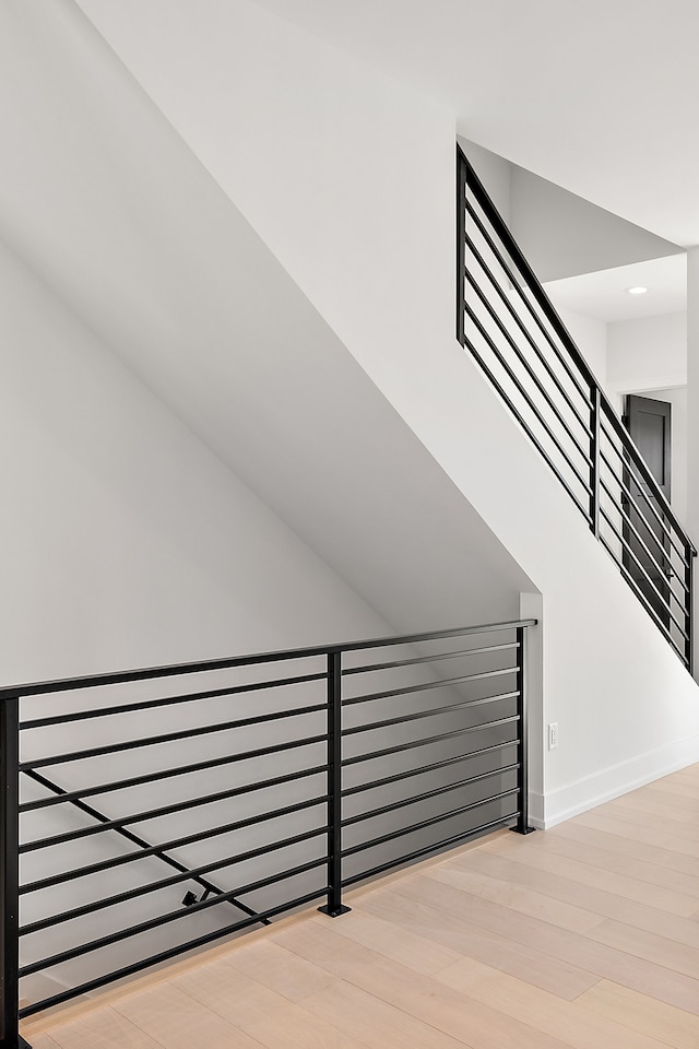 staircase featuring recessed lighting, radiator, wood finished floors, and baseboards
