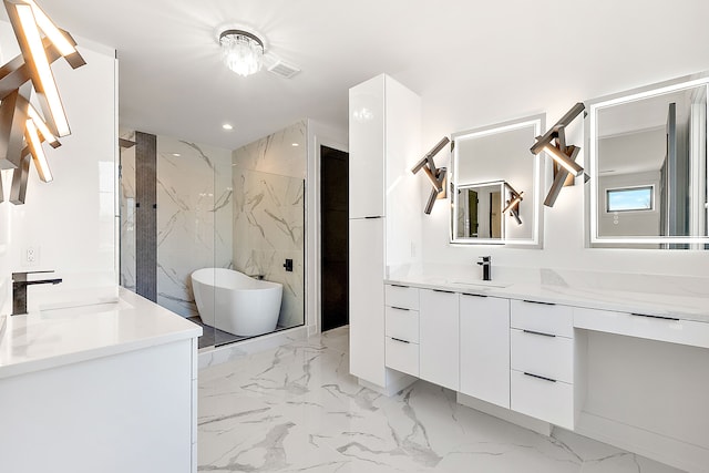 bathroom with a freestanding tub, visible vents, marble finish floor, and vanity