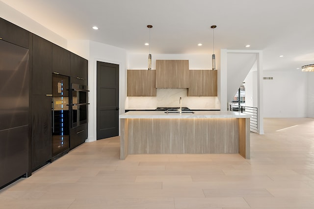 kitchen featuring modern cabinets, light countertops, a sink, and recessed lighting
