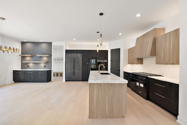 kitchen with high end appliances, modern cabinets, light countertops, and a sink