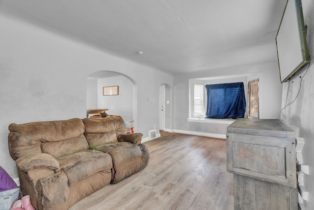 16171 Ilene St, Detroit, MI 48221 - living area with visible vents, baseboards, arched walkways, and wood finished floors