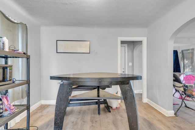 16171 Ilene St, Detroit, MI 48221 - office area featuring arched walkways, baseboards, a textured ceiling, and wood finished floors