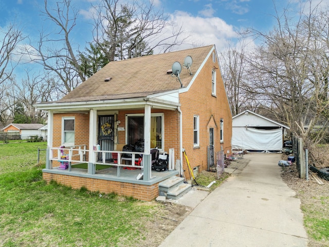 19965 Barlow St, Detroit, MI 48205 - view of front of property featuring concrete driveway, a front yard, a porch, brick siding, and a garage