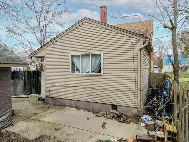 19965 Barlow St, Detroit, MI 48205 - view of side of property featuring a patio, a chimney, fence, and roof with shingles