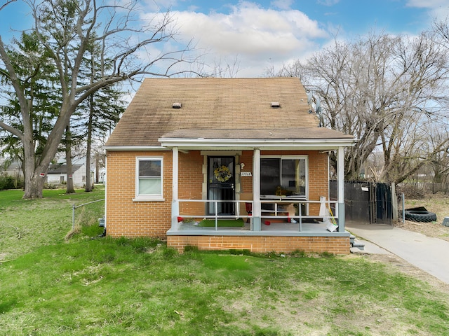 19965 Barlow St, Detroit, MI 48205 - rear view of house featuring brick siding, a porch, fence, and a yard