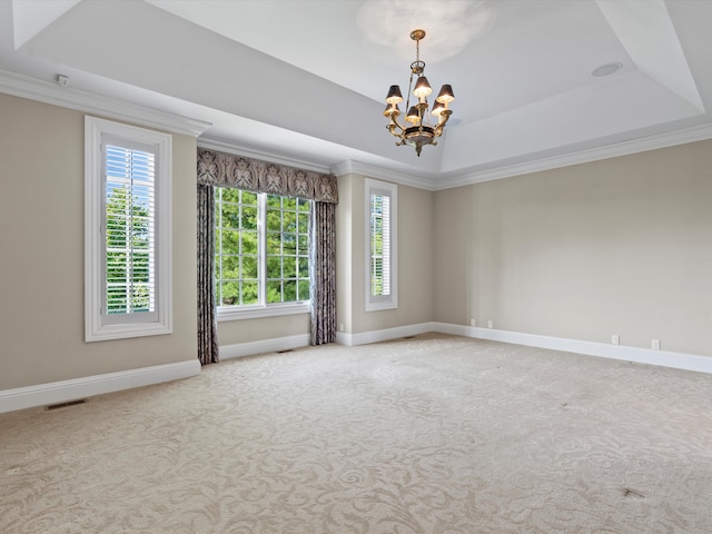 empty room featuring an inviting chandelier, carpet floors, baseboards, visible vents, and a tray ceiling