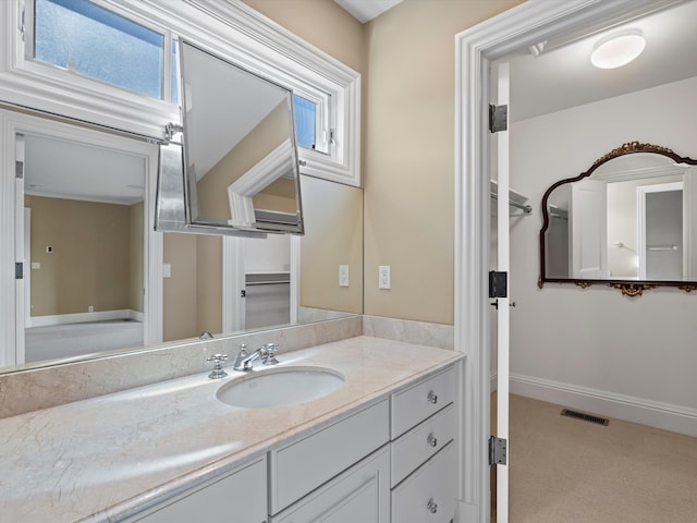 bathroom with baseboards, visible vents, a wealth of natural light, and vanity