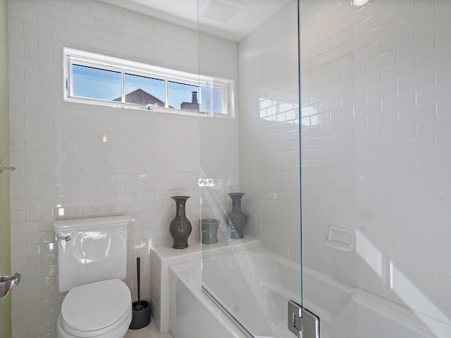 bathroom featuring combined bath / shower with glass door and toilet