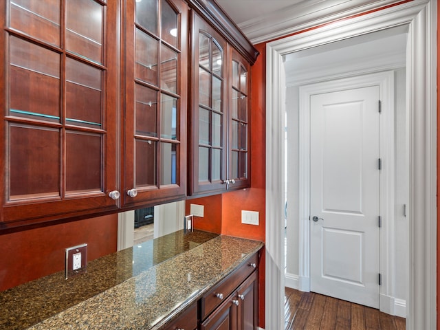 interior space featuring dark wood-style flooring, crown molding, and baseboards