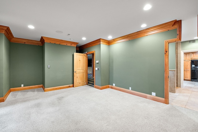 empty room with light colored carpet, recessed lighting, ornamental molding, and baseboards