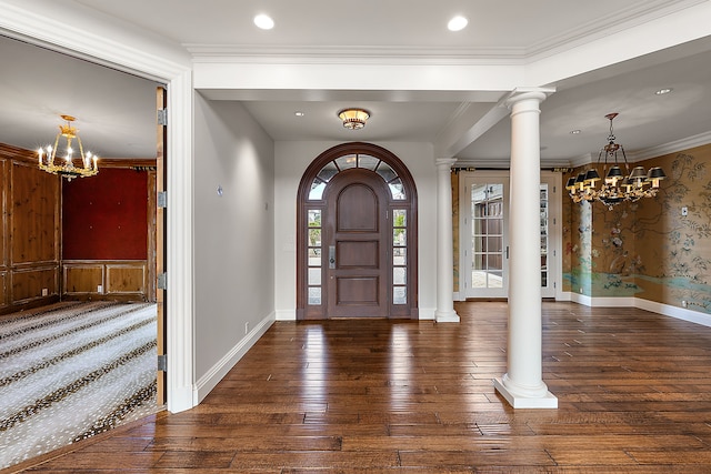 entryway with hardwood / wood-style floors, a chandelier, and ornate columns