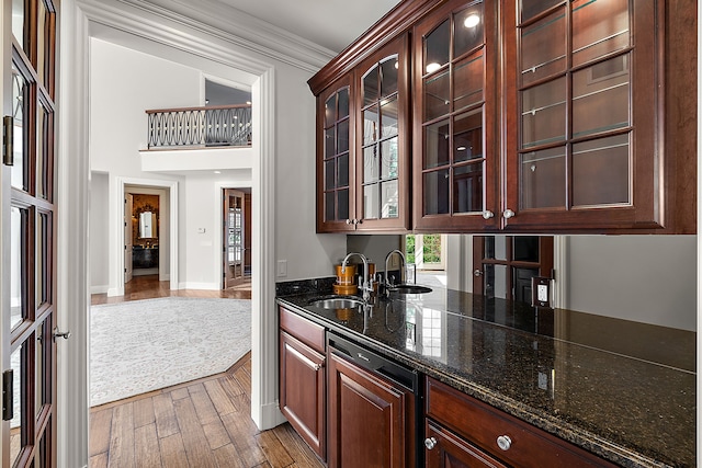 bar with baseboards, wood finished floors, crown molding, and a sink