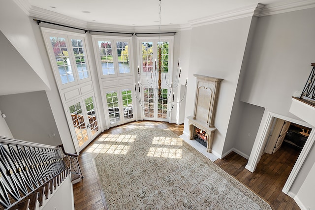 unfurnished living room featuring hardwood / wood-style flooring, a healthy amount of sunlight, and a high ceiling