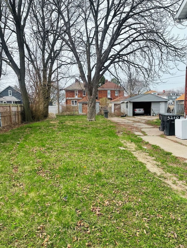 view of yard with a detached carport, fence, and an outdoor structure
