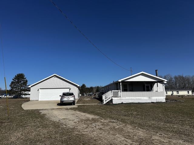 view of front of home with a front yard, an outdoor structure, covered porch, and a garage