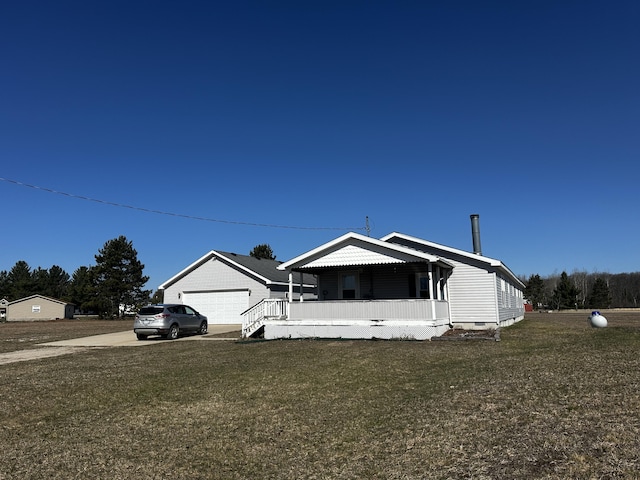view of front of house with a porch, a detached garage, crawl space, and a front yard