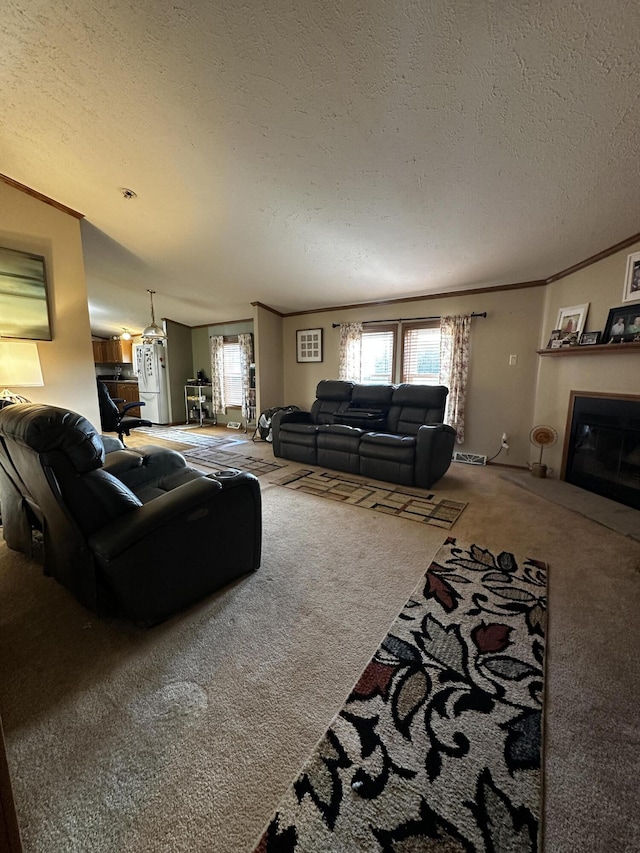 living room featuring carpet flooring, crown molding, a textured ceiling, and a glass covered fireplace