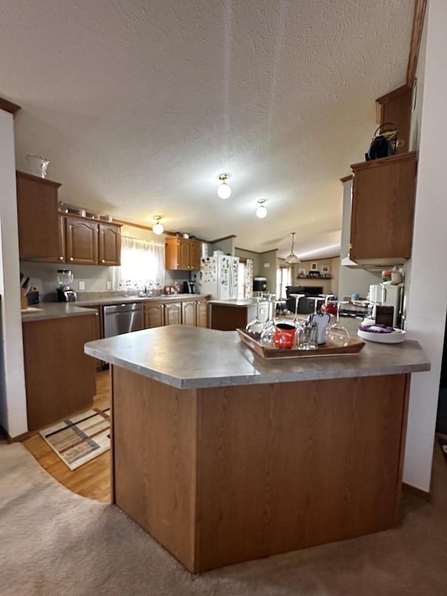 kitchen with lofted ceiling, a textured ceiling, stainless steel dishwasher, a peninsula, and light colored carpet