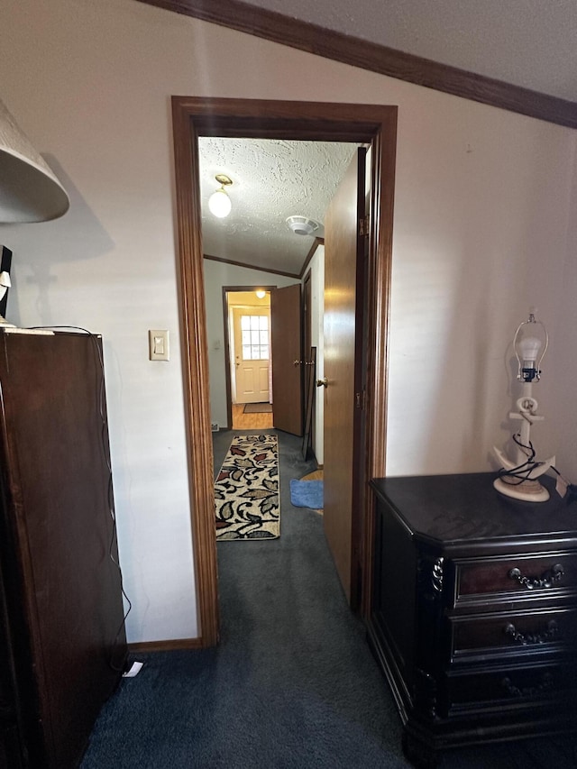 corridor featuring crown molding, a textured ceiling, and carpet flooring