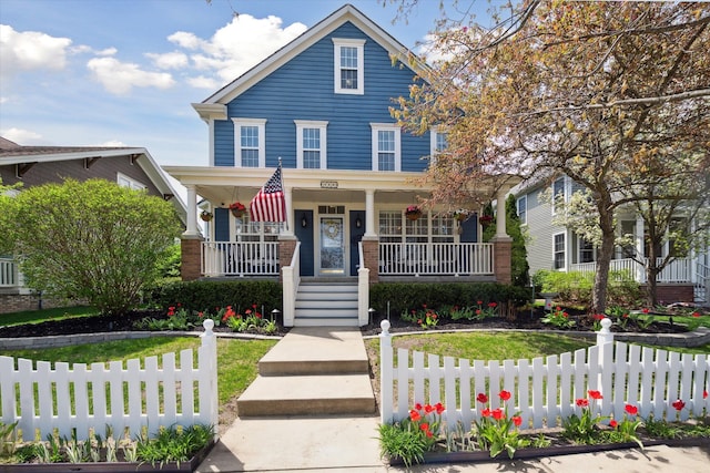 view of front of property with covered porch, fence private yard, and stairway