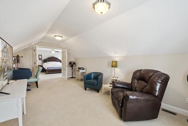 sitting room featuring carpet floors, baseboards, lofted ceiling, and visible vents