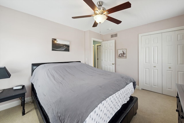 bedroom featuring ceiling fan, light carpet, baseboards, visible vents, and a closet